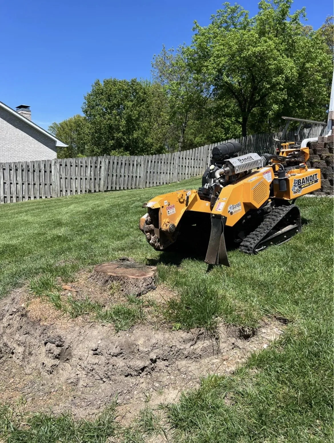 Stump grinder next to a stump in a yard